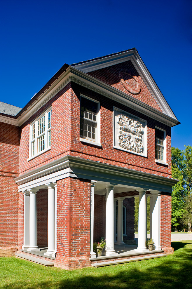 На фото: огромный, двухэтажный, кирпичный, коричневый дом в классическом стиле с двускатной крышей
