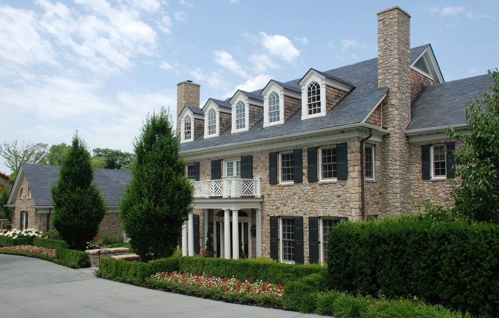 Imagen de fachada blanca clásica de dos plantas con revestimiento de piedra y tejado a dos aguas