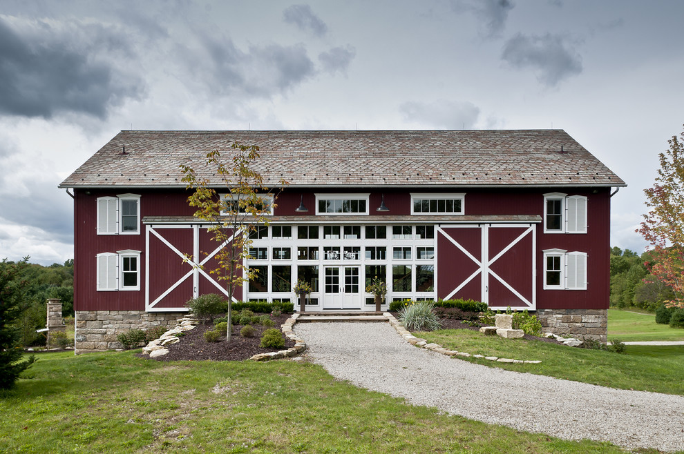 Foto della facciata di una casa grande country a tre piani con rivestimento in legno