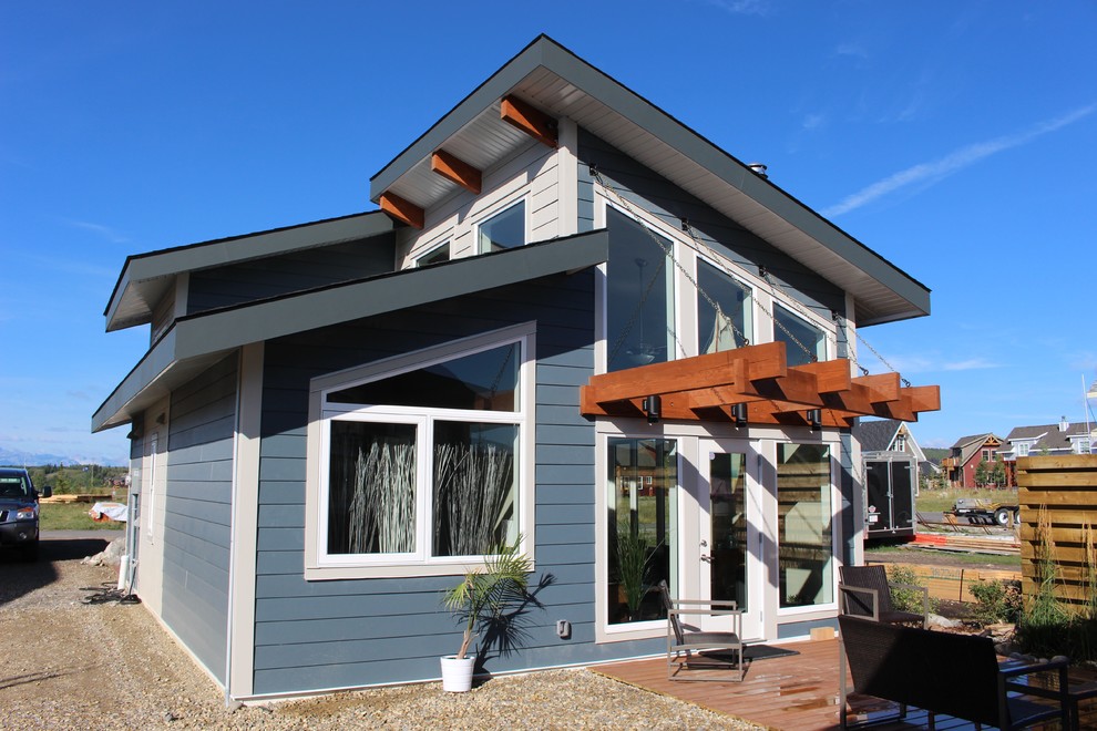 Cette photo montre une petite façade de maison bleue bord de mer en panneau de béton fibré de plain-pied avec un toit à deux pans.