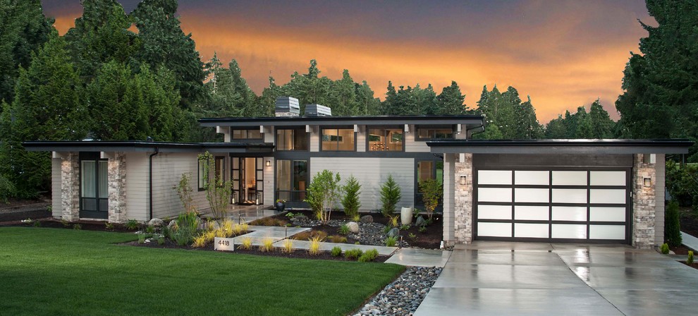Exemple d'une façade de maison grise tendance en panneau de béton fibré de taille moyenne et de plain-pied avec un toit plat et un toit mixte.