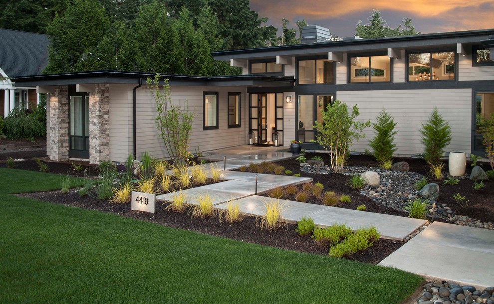 Photo of a medium sized and gey contemporary bungalow detached house in Seattle with concrete fibreboard cladding, a flat roof and a mixed material roof.