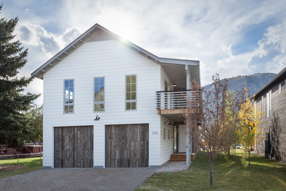 Aménagement d'une façade de maison blanche campagne en bois de taille moyenne et à un étage avec un toit à deux pans.
