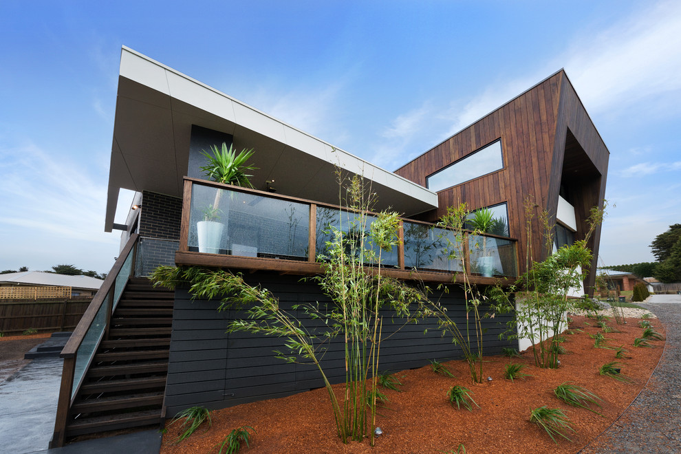 Esempio della facciata di una casa contemporanea a due piani con terreno in pendenza