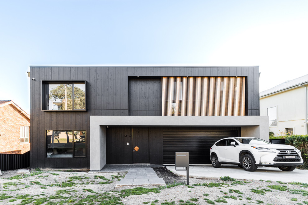 Idée de décoration pour une façade de maison grise design à un étage avec un toit plat et boîte aux lettres.