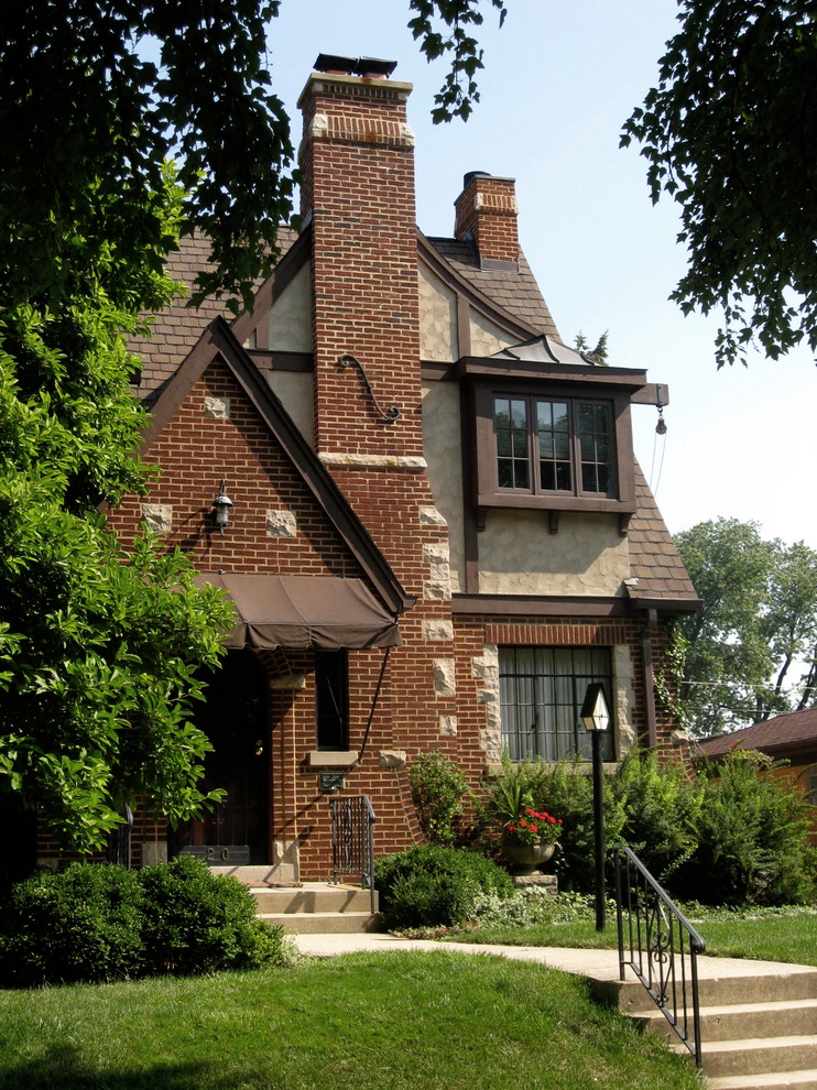 Cette image montre une façade de maison multicolore traditionnelle de taille moyenne et à deux étages et plus avec un revêtement mixte et un toit à deux pans.