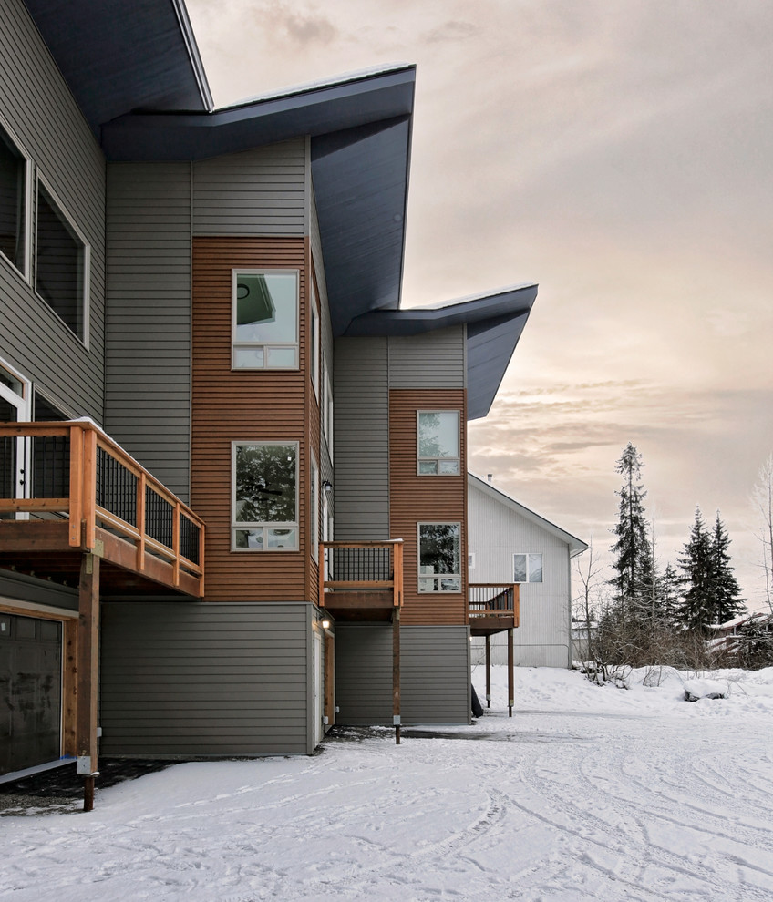 Immagine della facciata di una casa a schiera grigia contemporanea a due piani di medie dimensioni con rivestimento in legno, tetto piano, copertura in metallo o lamiera e abbinamento di colori