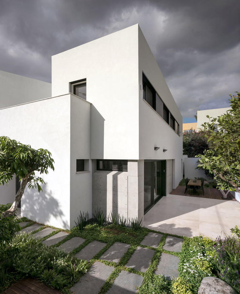 Mittelgroßes, Zweistöckiges Modernes Haus mit Putzfassade, weißer Fassadenfarbe und Flachdach in Tel Aviv