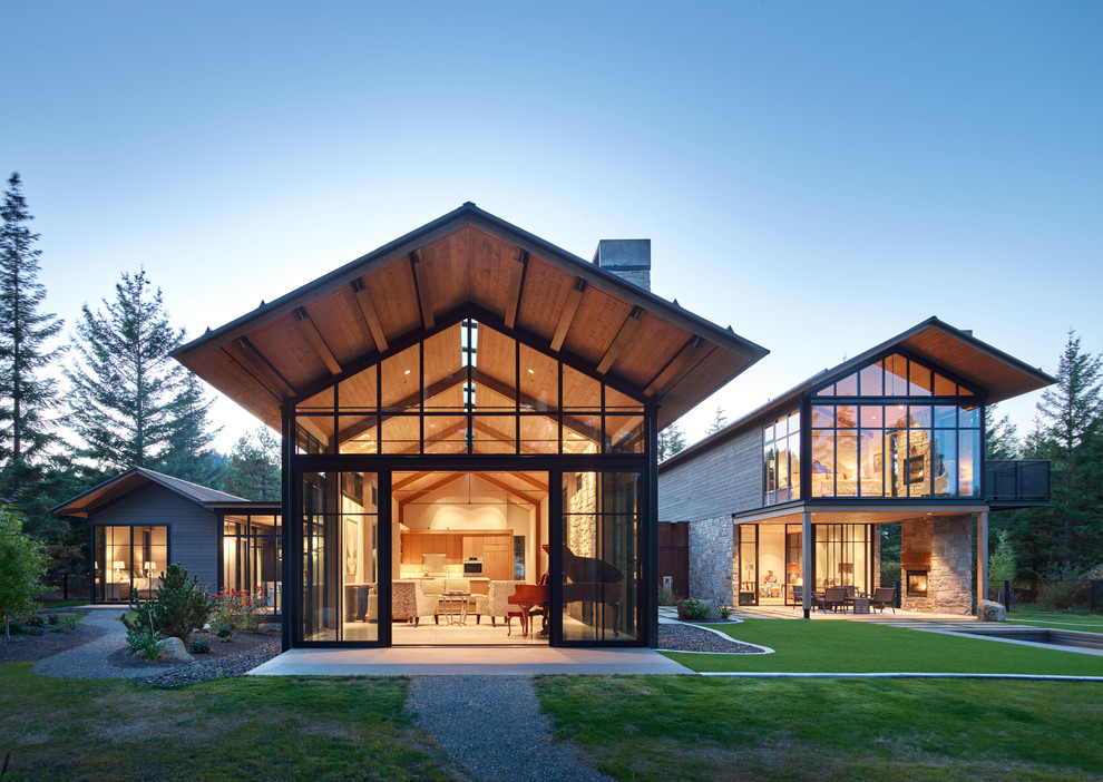 Стильный дизайн: двухэтажный, серый частный загородный дом в современном стиле с комбинированной облицовкой и двускатной крышей - последний тренд
