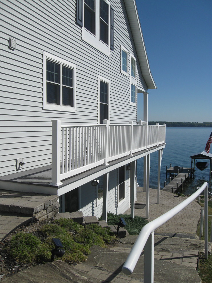 Mittelgroßes, Zweistöckiges Maritimes Haus mit Vinylfassade, grauer Fassadenfarbe und Satteldach in New York