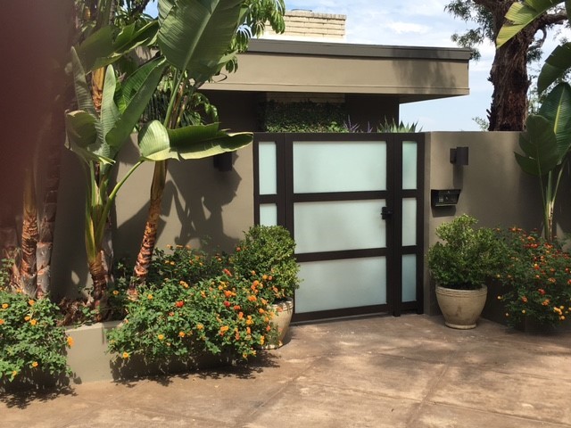 Foto de fachada de casa beige tropical de tamaño medio de dos plantas con revestimiento de estuco y tejado plano