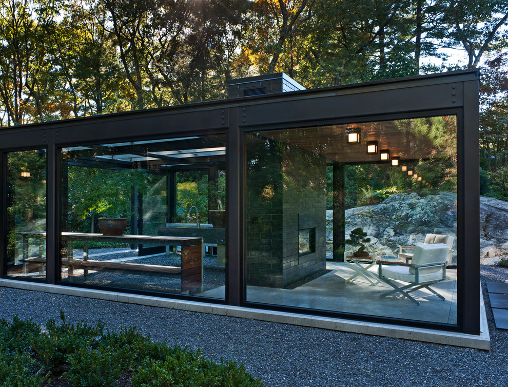 Esempio della facciata di una casa piccola moderna a un piano con rivestimento in vetro