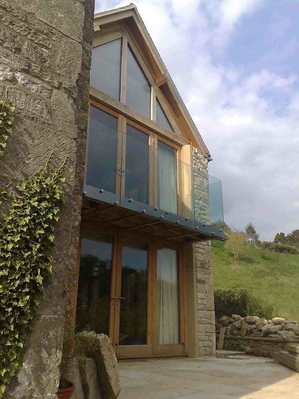 Réalisation d'une façade de maison minimaliste en verre de taille moyenne et à un étage.