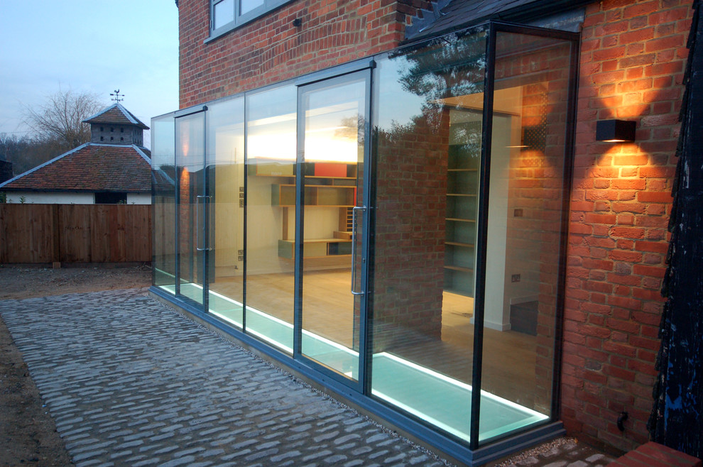 Ispirazione per la facciata di una casa contemporanea a un piano di medie dimensioni con rivestimento in vetro