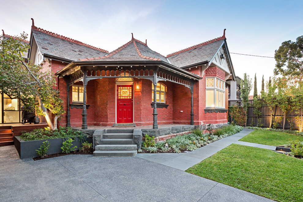 Пример оригинального дизайна: одноэтажный, кирпичный, красный частный загородный дом в викторианском стиле с вальмовой крышей и крышей из гибкой черепицы