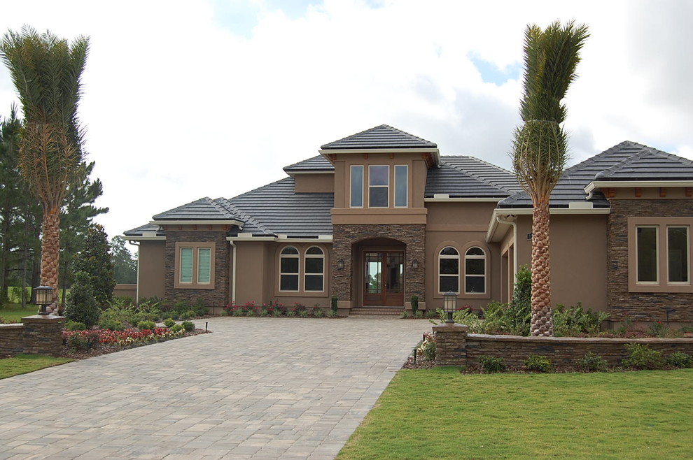 Стильный дизайн: двухэтажный, коричневый дом в современном стиле с облицовкой из цементной штукатурки и вальмовой крышей - последний тренд