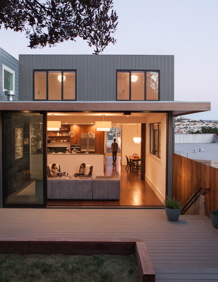Foto de fachada gris minimalista grande de tres plantas con revestimiento de madera y tejado plano
