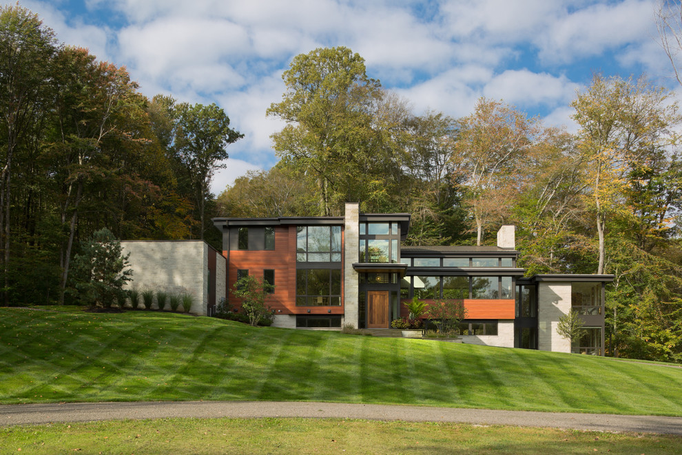 Diseño de fachada de casa multicolor minimalista grande de tres plantas con revestimiento de madera y tejado plano