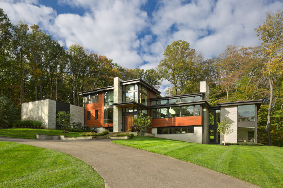 Imagen de fachada de casa multicolor moderna grande de tres plantas con revestimiento de madera y tejado plano