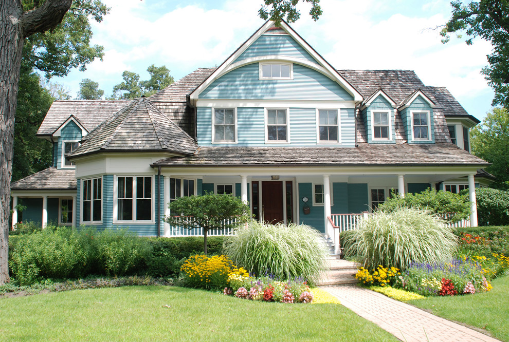 Imagen de fachada de casa azul tradicional de dos plantas con revestimiento de vinilo