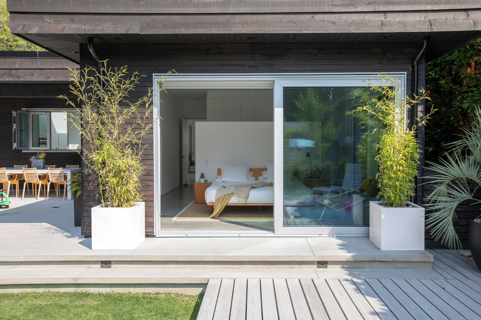 Идея дизайна: деревянный, коричневый, большой, двухэтажный частный загородный дом в стиле модернизм с плоской крышей и металлической крышей