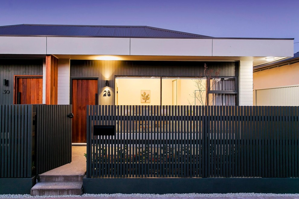 Immagine della facciata di una casa bifamiliare multicolore contemporanea a un piano di medie dimensioni con rivestimento in vinile e copertura in metallo o lamiera