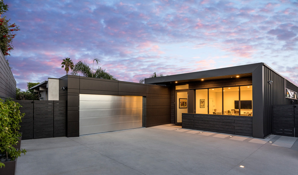 Black contemporary bungalow detached house in Los Angeles with metal cladding and a flat roof.