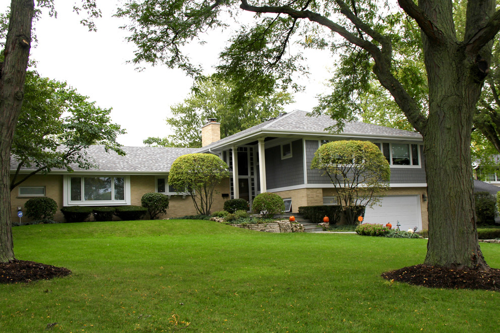 Imagen de fachada de casa gris clásica de tamaño medio a niveles con revestimiento de aglomerado de cemento, tejado de teja de madera y tejado a dos aguas