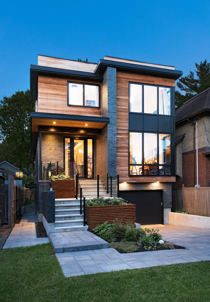 Diseño de fachada de casa negra contemporánea de tres plantas con revestimiento de madera y tejado plano