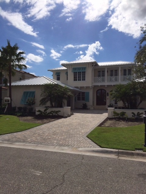 Photo of a large and white coastal two floor render detached house in Orlando with a hip roof and a metal roof.