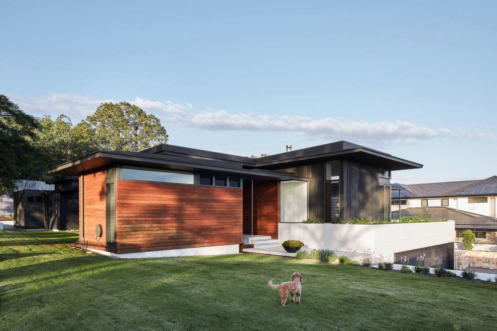 Modelo de fachada de casa marrón contemporánea con revestimiento de madera y tejado de un solo tendido