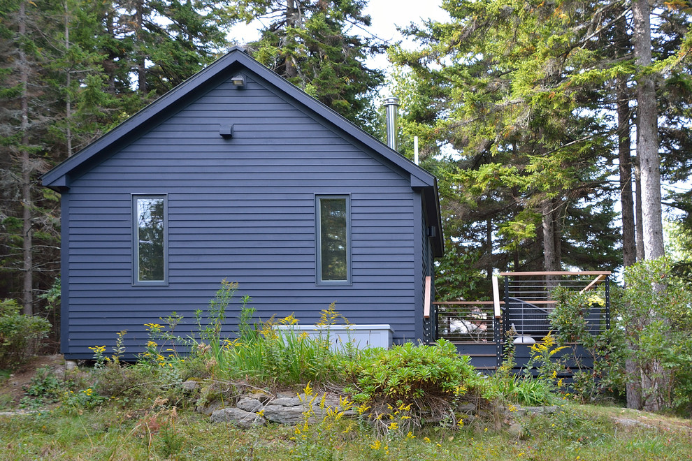 На фото: маленький, одноэтажный, деревянный, черный дом в современном стиле с двускатной крышей для на участке и в саду с