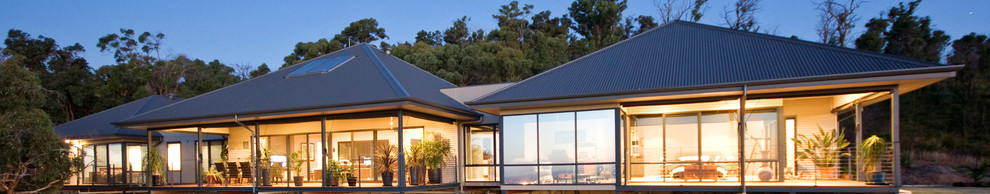 Diseño de fachada de casa beige grande de una planta con revestimientos combinados, tejado a cuatro aguas y tejado de metal