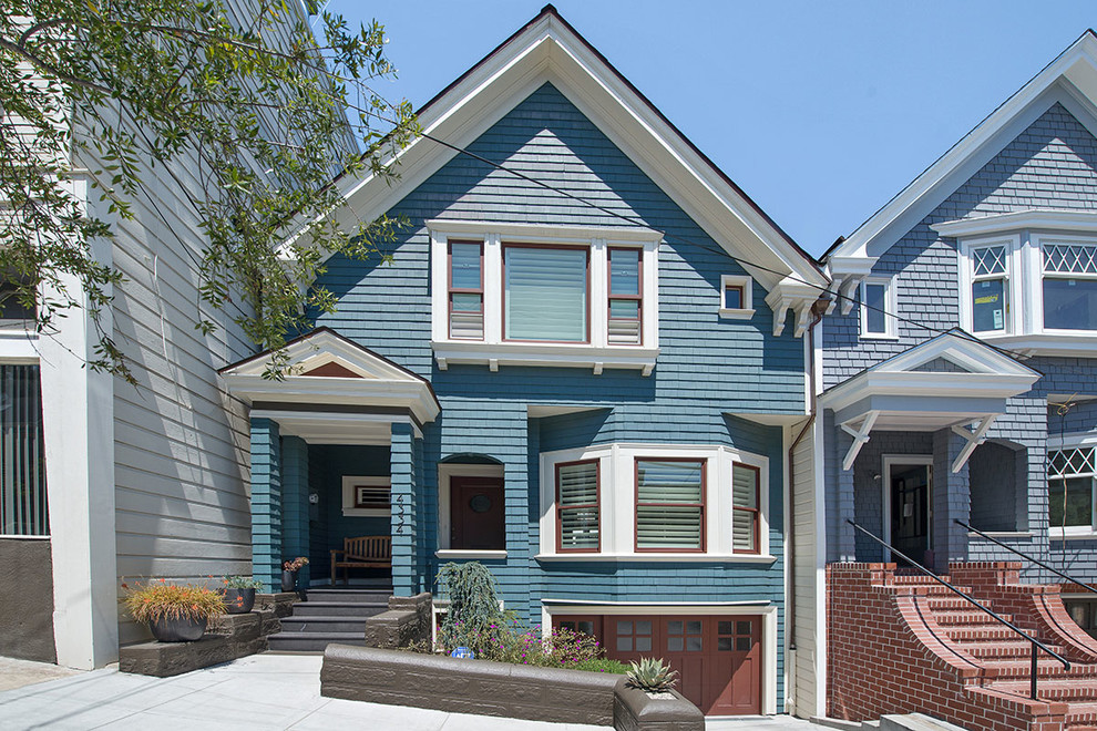 Imagen de fachada de casa azul clásica de tamaño medio de dos plantas con revestimiento de madera, tejado a dos aguas y tejado de teja de madera