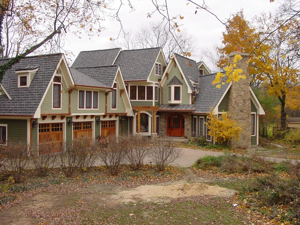 Réalisation d'une très grande façade de maison verte craftsman à un étage avec un revêtement mixte, un toit à deux pans et un toit mixte.