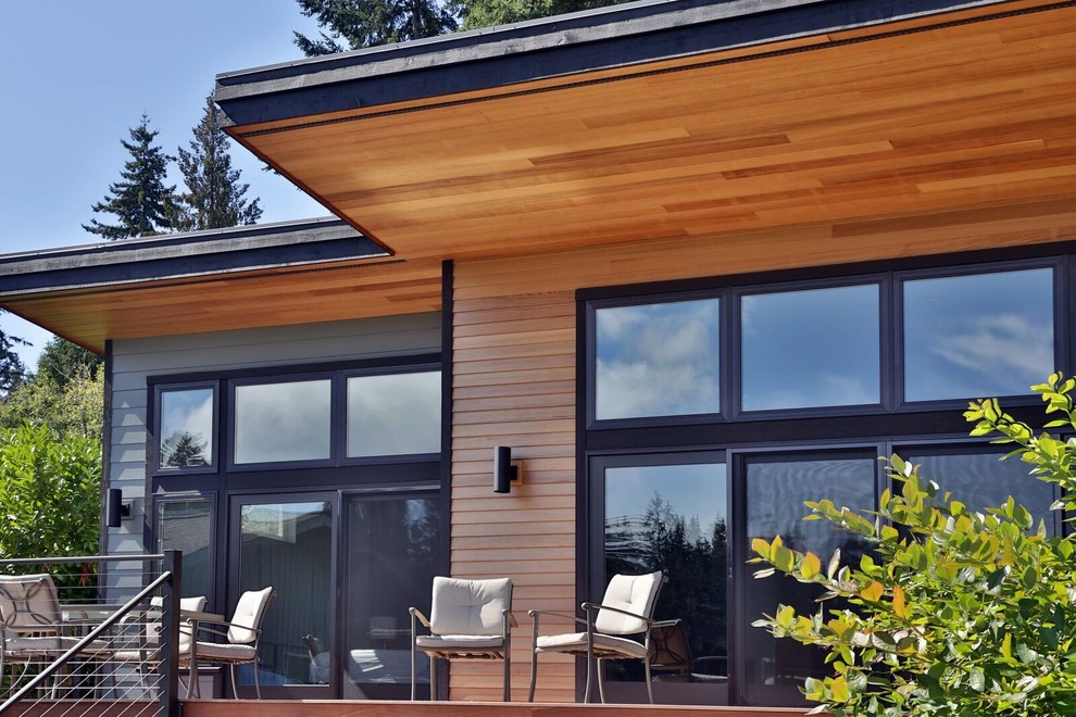Photo of a medium sized and gey modern bungalow house exterior in Seattle with mixed cladding and a flat roof.