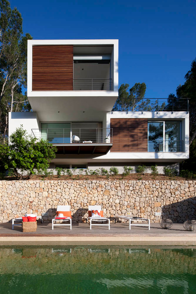 На фото: двухэтажный, большой, белый дом в стиле модернизм с плоской крышей и комбинированной облицовкой с