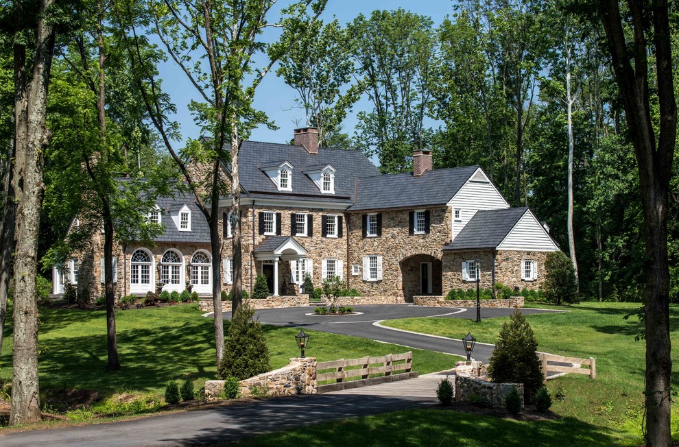 Cette photo montre une grande façade de maison marron chic en pierre à deux étages et plus avec un toit à deux pans et un toit en shingle.