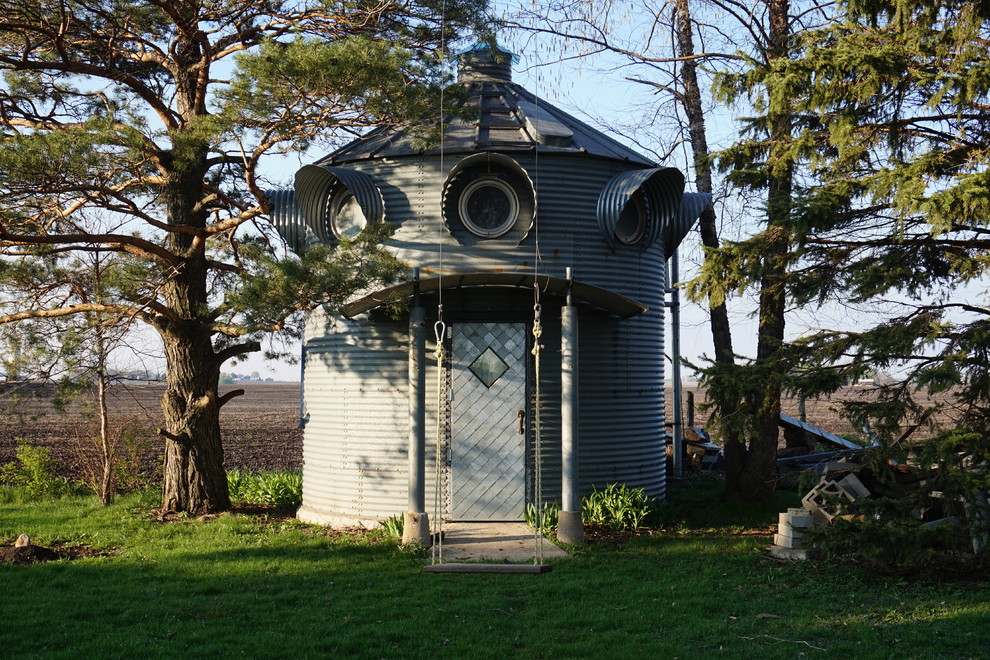 Bild på ett litet industriellt grått hus, med två våningar och metallfasad