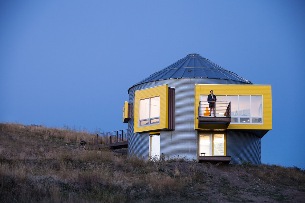 Idee per la facciata di una casa piccola gialla moderna a due piani con rivestimento in metallo
