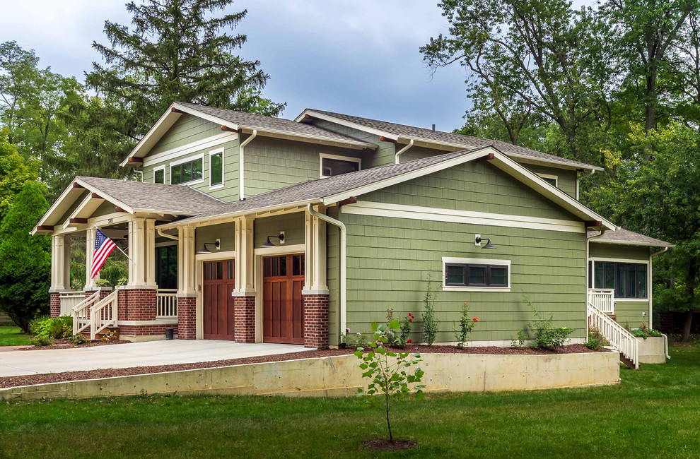 Cette photo montre une façade de maison verte craftsman en panneau de béton fibré et bardeaux de taille moyenne et à un étage avec un toit à deux pans, un toit en shingle et un toit gris.