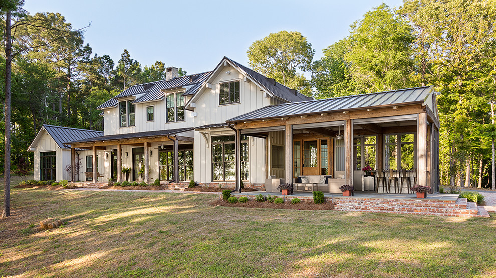 Farmhouse beige two-story exterior home photo in New Orleans with a metal roof