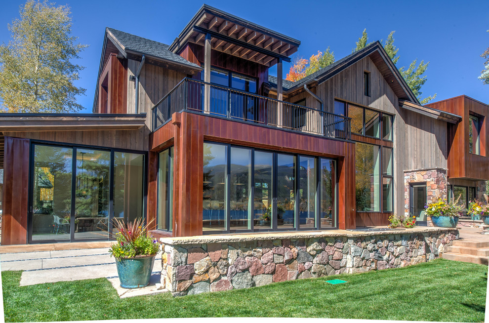 Large rustic two floor house exterior in Denver with wood cladding and a pitched roof.