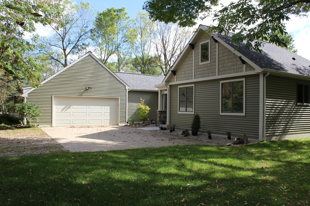 Cette image montre une façade de maison verte traditionnelle de taille moyenne et de plain-pied avec un revêtement en vinyle, un toit à deux pans et un toit en shingle.