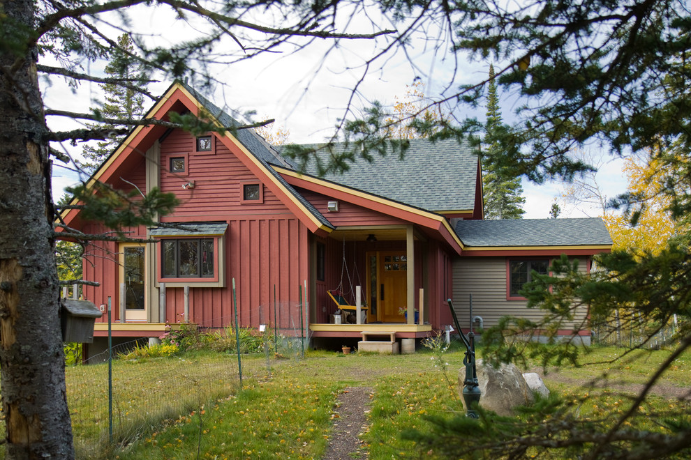 Ejemplo de fachada roja de estilo de casa de campo de tamaño medio de dos plantas con revestimiento de madera