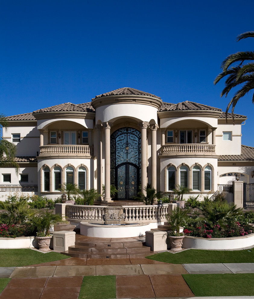 Стильный дизайн: огромный дом в средиземноморском стиле с облицовкой из цементной штукатурки и вальмовой крышей - последний тренд