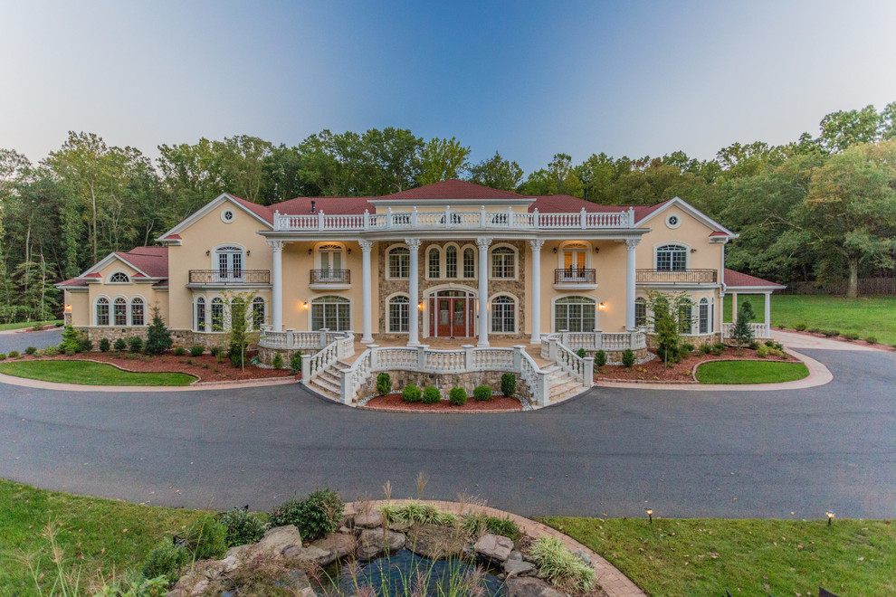 Huge elegant beige three-story stucco house exterior photo in DC Metro with a hip roof and a shingle roof