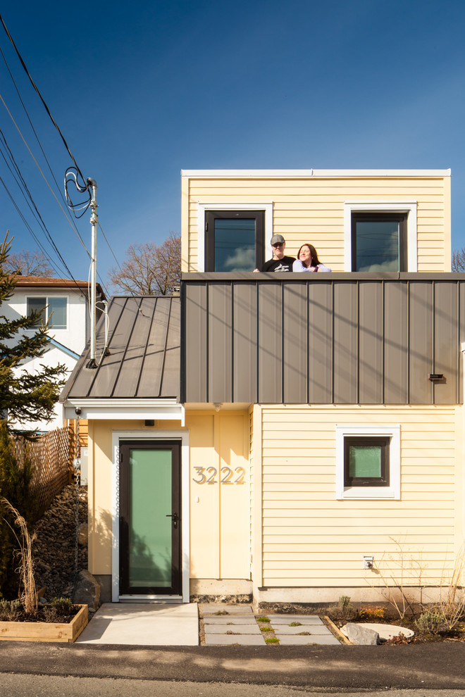 На фото: маленький, желтый, двухэтажный мини дом в стиле неоклассика (современная классика) с плоской крышей и зеленой крышей для на участке и в саду с