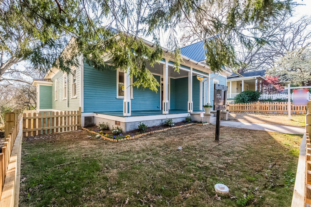 Cette photo montre une façade de maison bleue chic en bois de taille moyenne et de plain-pied avec un toit à quatre pans.