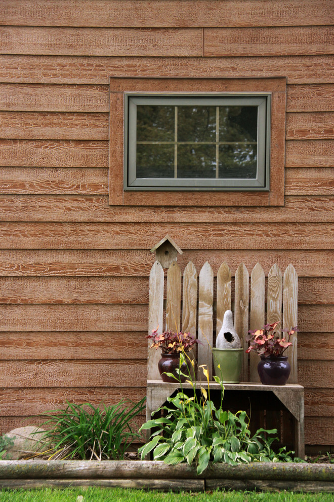 Exemple d'une façade de maison marron chic en bois à un étage avec un toit à deux pans.